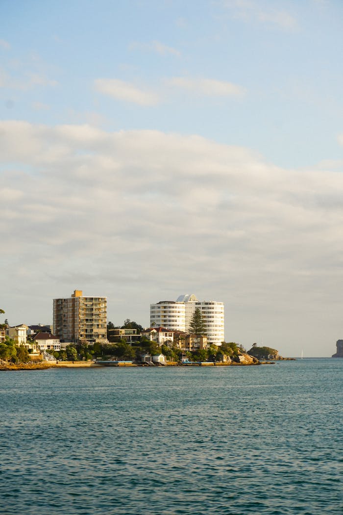 A coastal city view featuring modern high-rise apartments against a clear sky.
